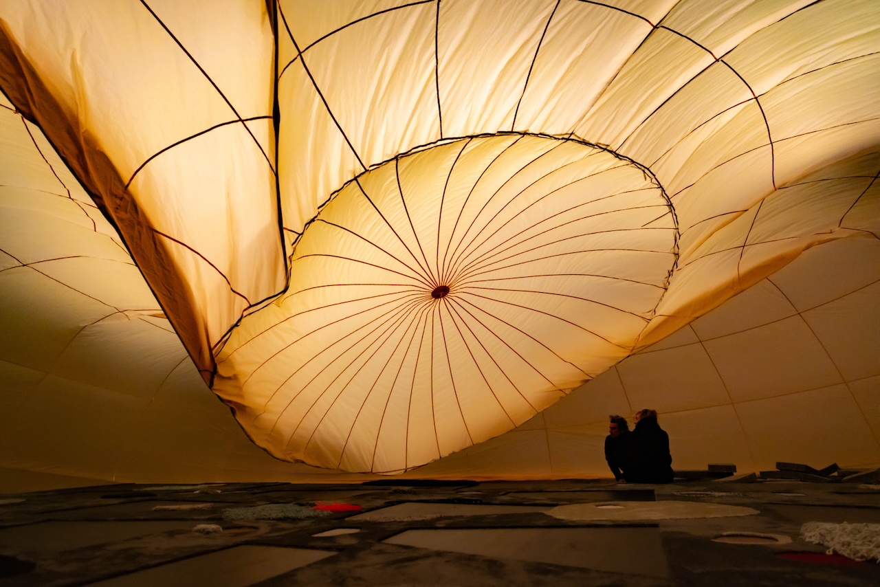 In "Unter Uns", the audience gathers under a movable fabric canopy. (Photo © Arthur Bauer)